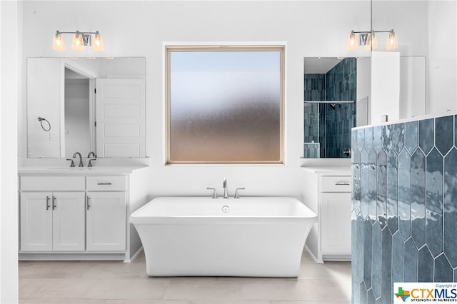 bathroom with tile patterned flooring, vanity, and a tub