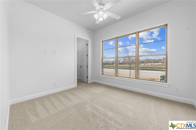 carpeted spare room with ceiling fan