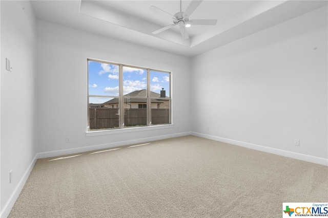 unfurnished room featuring carpet flooring, ceiling fan, and a tray ceiling