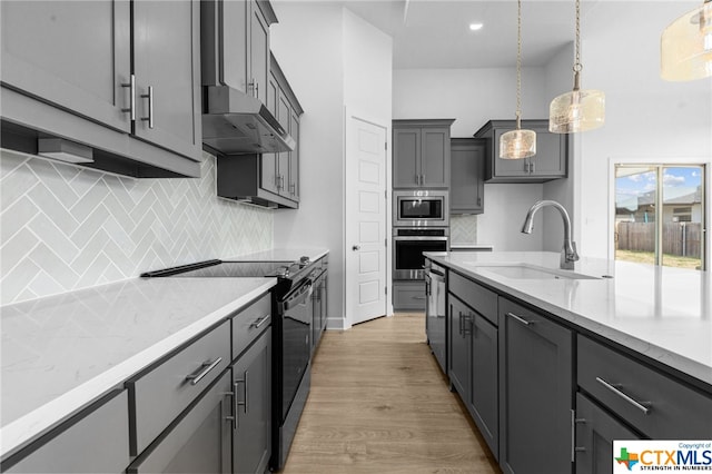 kitchen featuring sink, hanging light fixtures, backsplash, gray cabinets, and appliances with stainless steel finishes