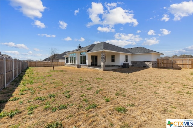 back of house with central air condition unit, a yard, and a patio