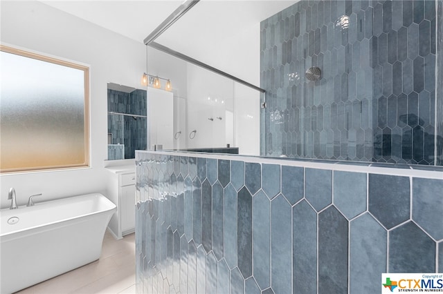 bathroom featuring tile patterned floors, vanity, and shower with separate bathtub