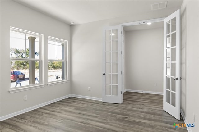 unfurnished room featuring dark hardwood / wood-style flooring and french doors