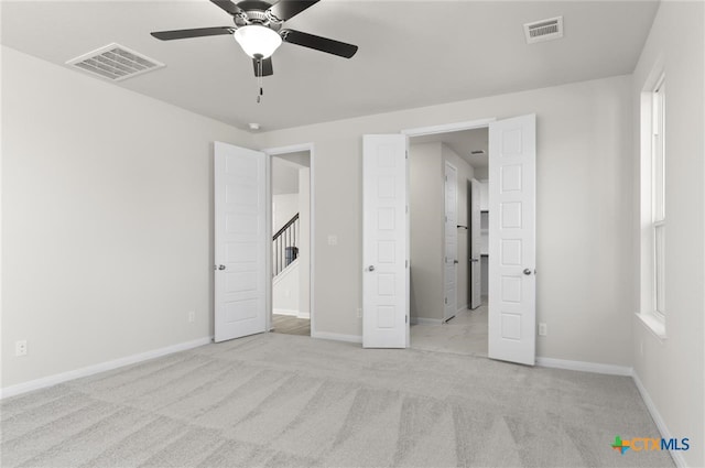 unfurnished bedroom with light carpet and ceiling fan