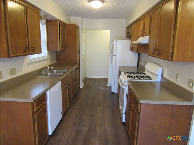 kitchen with a textured ceiling, white appliances, dark hardwood / wood-style floors, and sink