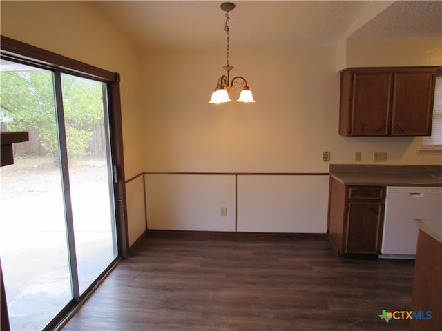 unfurnished dining area featuring dark hardwood / wood-style flooring, a notable chandelier, and a textured ceiling