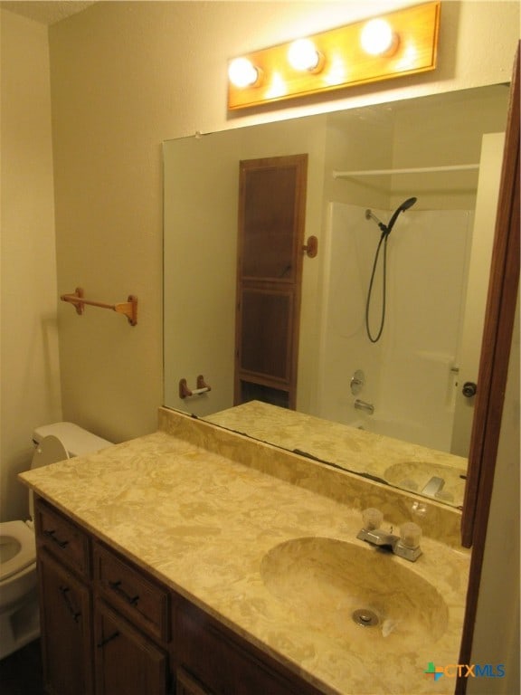 full bathroom featuring toilet, shower / bathing tub combination, and vanity