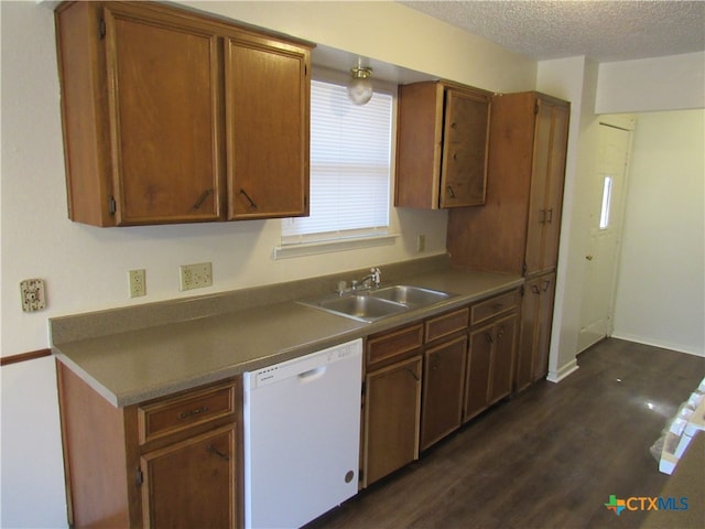 kitchen featuring a textured ceiling, dark wood-type flooring, sink, and white dishwasher