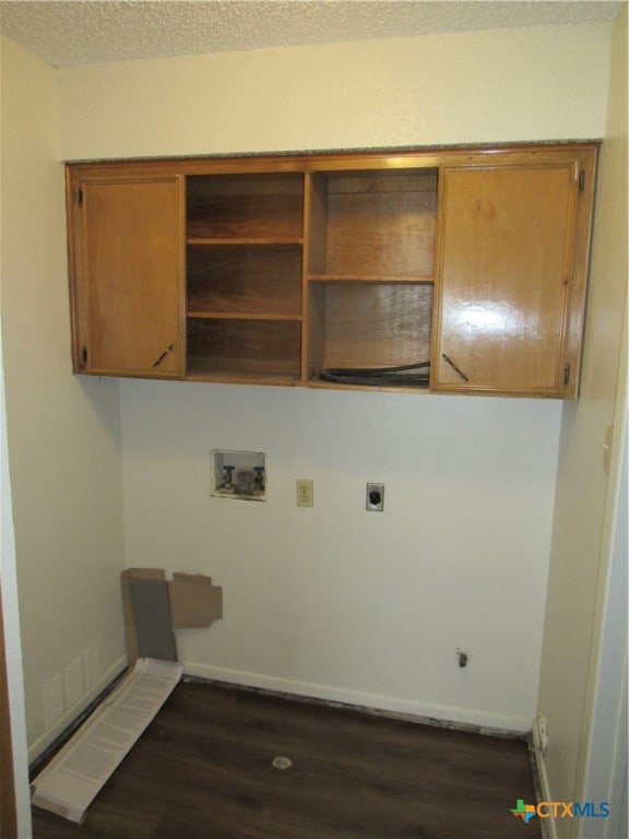 washroom with cabinets, washer hookup, dark hardwood / wood-style floors, a textured ceiling, and hookup for an electric dryer