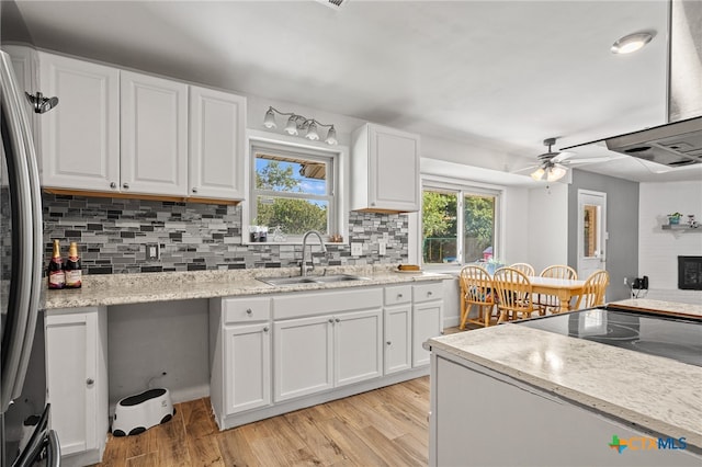 kitchen featuring ceiling fan, white cabinetry, sink, and light wood-type flooring