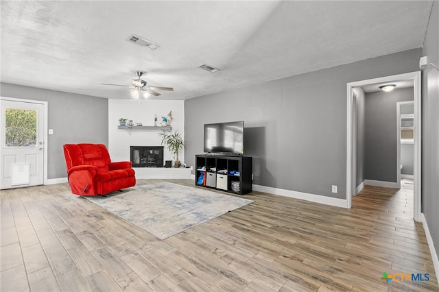 living room featuring a textured ceiling, hardwood / wood-style floors, and ceiling fan