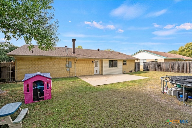 rear view of house featuring a lawn and a patio