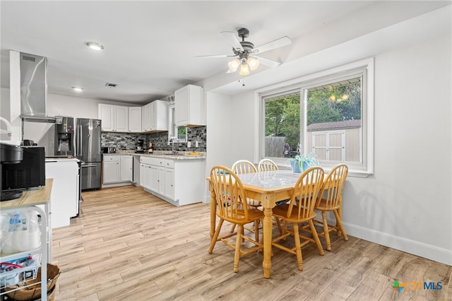 dining room with ceiling fan, sink, and light hardwood / wood-style flooring