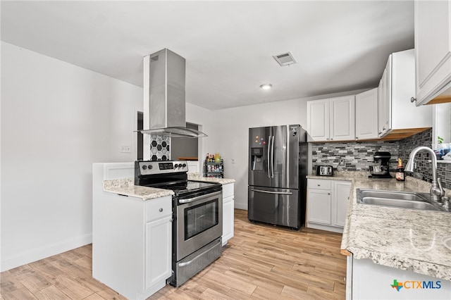 kitchen with wall chimney exhaust hood, sink, white cabinetry, light wood-type flooring, and appliances with stainless steel finishes