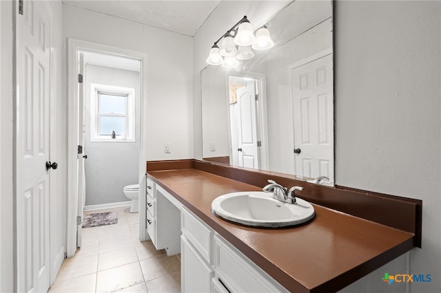 bathroom with vanity, tile patterned flooring, and toilet