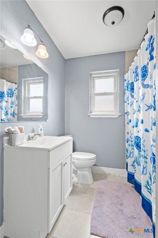 bathroom with tile patterned flooring, curtained shower, vanity, and toilet