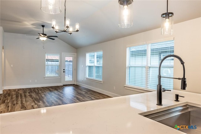 kitchen featuring sink, vaulted ceiling, dark hardwood / wood-style flooring, pendant lighting, and ceiling fan