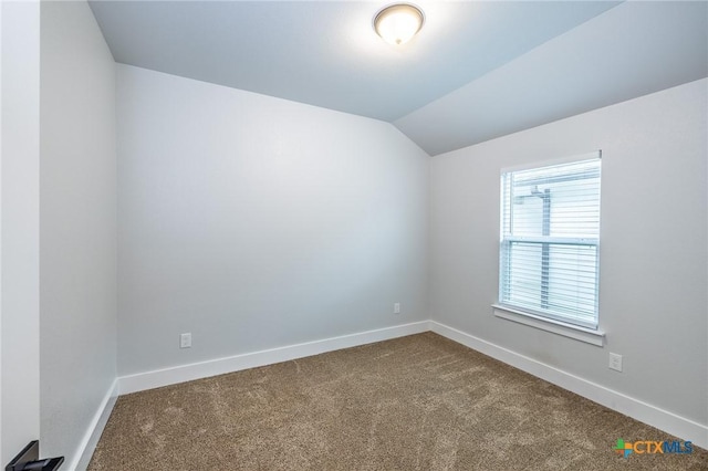 unfurnished room featuring carpet floors and vaulted ceiling