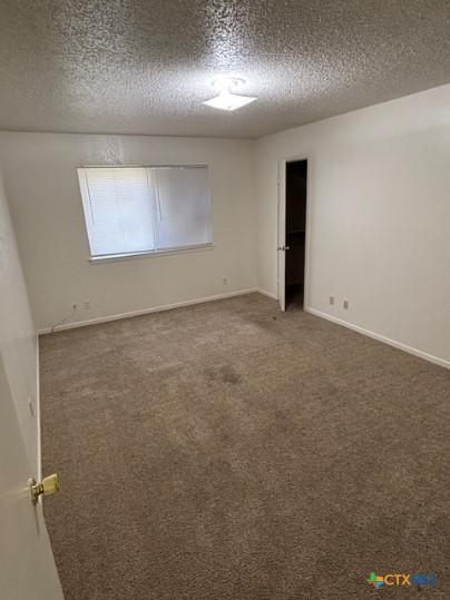 3206 Tallwood Dr, Killeen, TX 76549 - carpeted empty room featuring a textured ceiling and baseboards