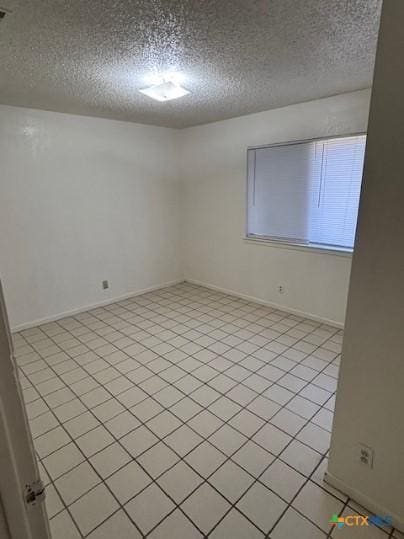 3206 Tallwood Dr, Killeen, TX 76549 - empty room with a textured ceiling and light tile patterned flooring