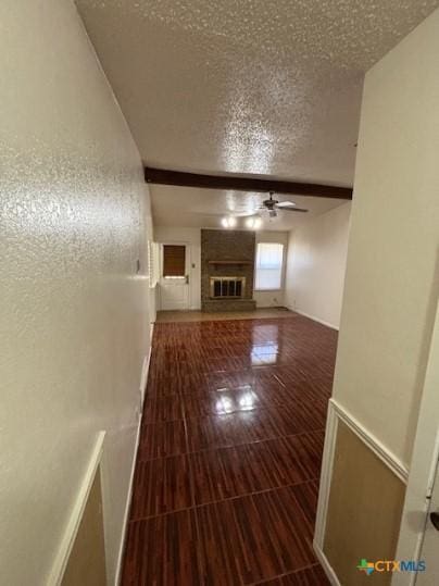 3206 Tallwood Dr, Killeen, TX 76549 - unfurnished living room with a textured ceiling, a ceiling fan, and a fireplace