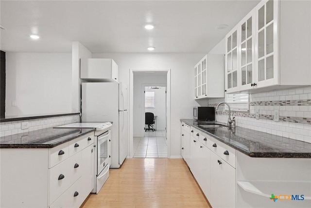 1334 Carnation Ln, New Braunfels, TX 78130 - kitchen with white appliances, decorative backsplash, white cabinets, dark stone counters, and recessed lighting