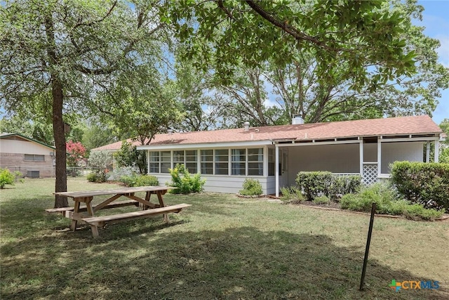 1334 Carnation Ln, New Braunfels, TX 78130 - rear view of house with a sunroom, a lawn, and a shingled roof