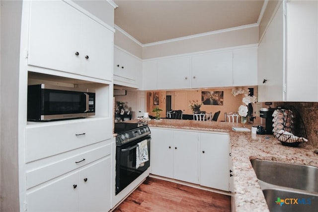 2303 Terrace Ave, Victoria, TX 77901 - kitchen featuring ornamental molding, white cabinets, stainless steel microwave, and black range with gas stovetop