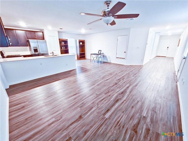 unfurnished living room featuring sink, ceiling fan, and light wood-type flooring