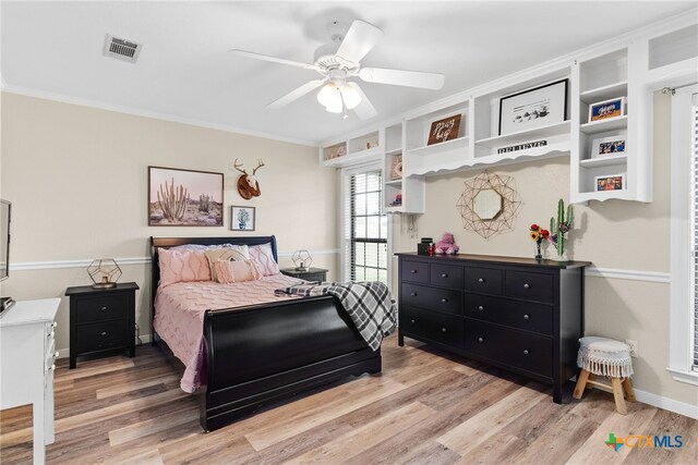 bedroom featuring ceiling fan, light wood-type flooring, and crown molding