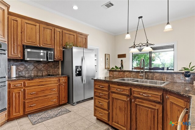 kitchen with stainless steel appliances, sink, ornamental molding, light tile patterned floors, and hanging light fixtures