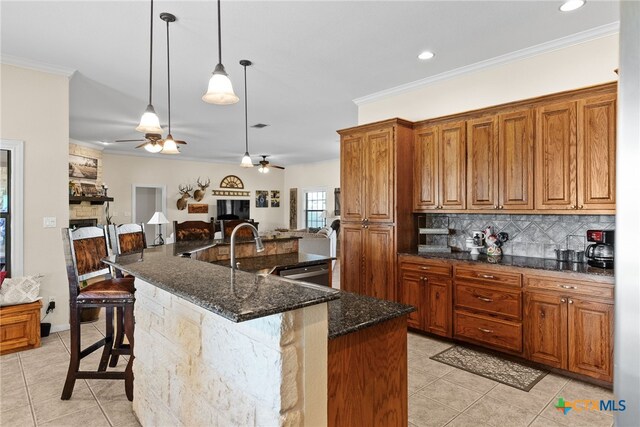 kitchen with a large island, dark stone countertops, a breakfast bar, and crown molding