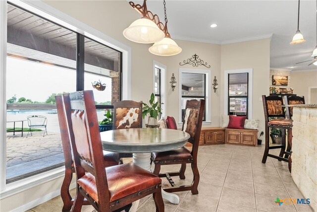 tiled dining room featuring ornamental molding and ceiling fan