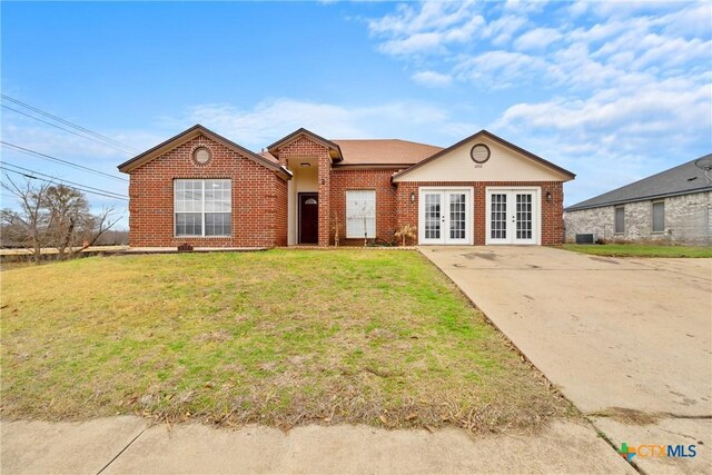 view of front of property featuring a front yard and french doors