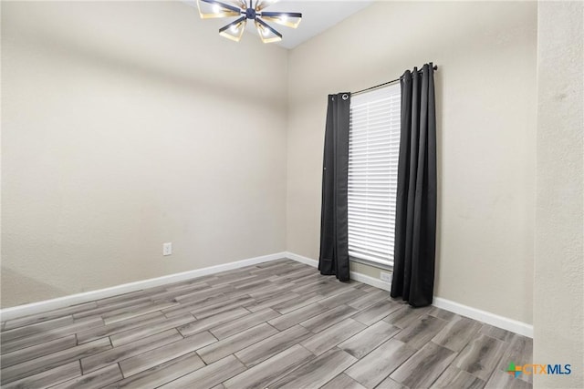 empty room with a chandelier and light hardwood / wood-style floors