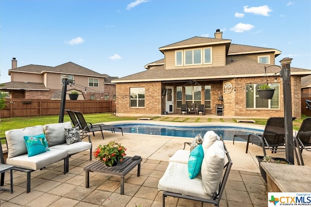 back of property featuring an outdoor living space, a fenced in pool, and a patio area