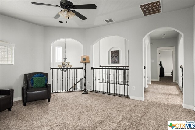 living area with light colored carpet and ceiling fan