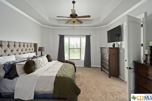 bedroom featuring ceiling fan, ornamental molding, a raised ceiling, and light colored carpet