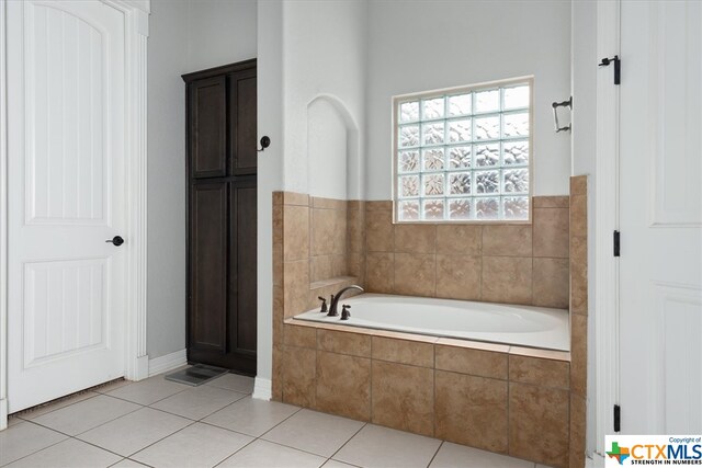 bathroom featuring tile patterned flooring and tiled tub