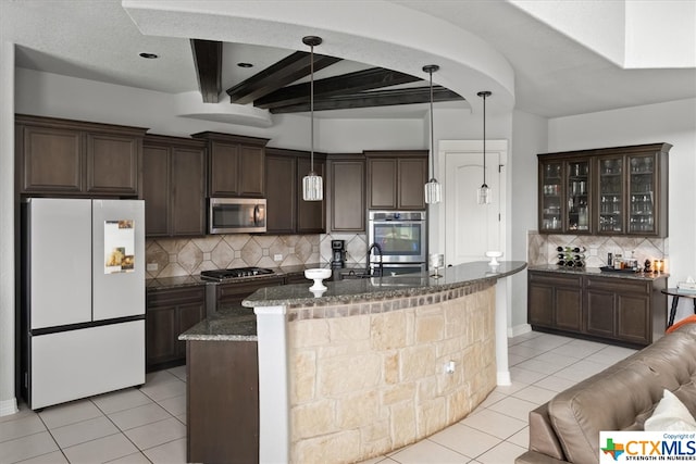 kitchen featuring hanging light fixtures, light tile patterned floors, appliances with stainless steel finishes, and tasteful backsplash