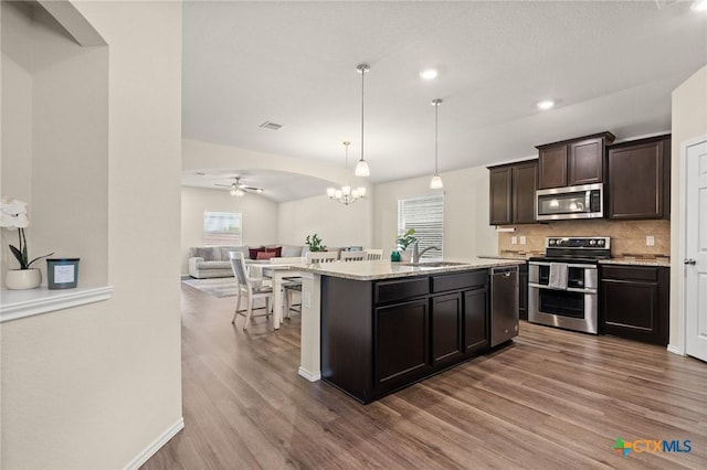2520 Cortona St, Harker Heights, TX 76548 - kitchen featuring appliances with stainless steel finishes, wood finished floors, open floor plan, ceiling fan, and tasteful backsplash