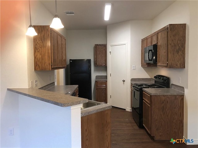 kitchen featuring dark wood-style flooring, black appliances, visible vents, a peninsula, and pendant lighting