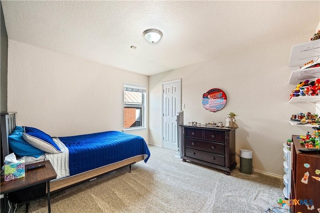 carpeted bedroom with a textured wall, a textured ceiling, and baseboards