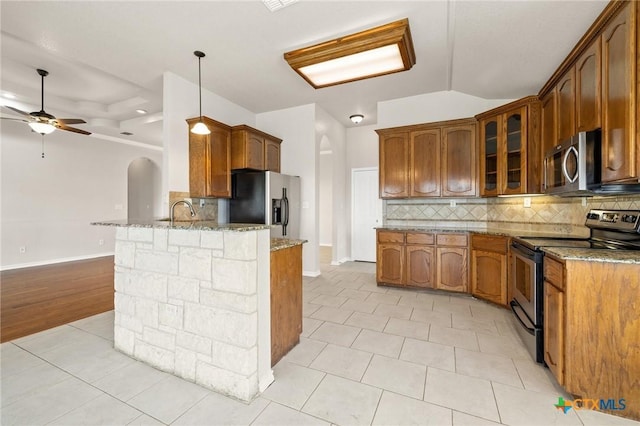 5620 Drystone Ln, Killeen, TX 76542 - kitchen with appliances with stainless steel finishes, a peninsula, light stone counters, glass insert cabinets, and tasteful backsplash