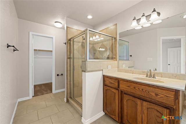 5620 Drystone Ln, Killeen, TX 76542 - bathroom with a shower stall, a walk in closet, baseboards, and tile patterned flooring