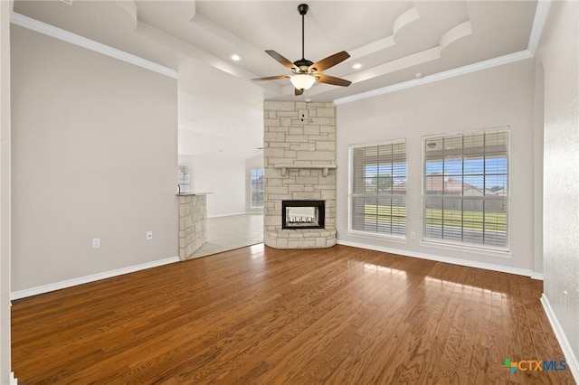 5620 Drystone Ln, Killeen, TX 76542 - unfurnished living room with a ceiling fan, a fireplace, a tray ceiling, wood finished floors, and crown molding