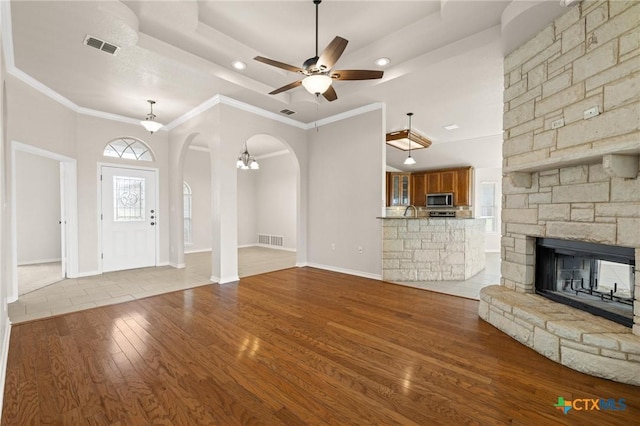 5620 Drystone Ln, Killeen, TX 76542 - unfurnished living room with arched walkways, a ceiling fan, wood finished floors, recessed lighting, and a stone fireplace