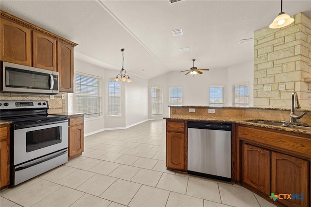 5620 Drystone Ln, Killeen, TX 76542 - kitchen with appliances with stainless steel finishes, a sink, tasteful backsplash, brown cabinetry, and lofted ceiling