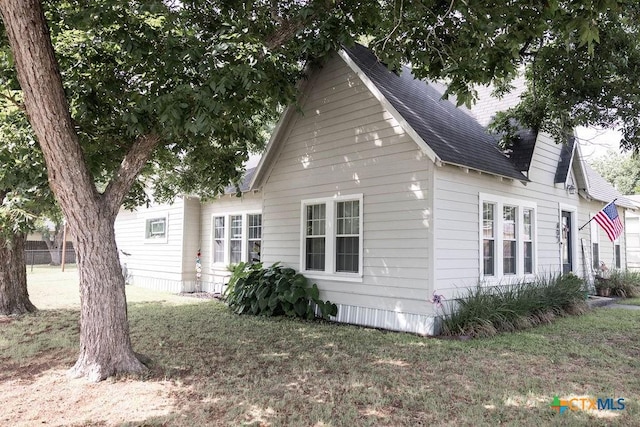 403 E 13th St, Shiner, TX 77984 - view of home's exterior with a yard and a shingled roof