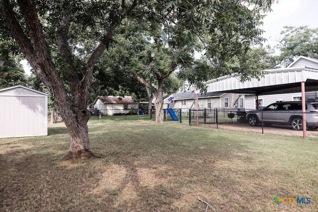 403 E 13th St, Shiner, TX 77984 - view of yard with a playground, a detached carport, and a storage unit